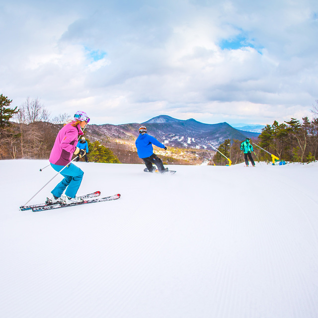 A group skiing and snowboarding at Massanutten Resort